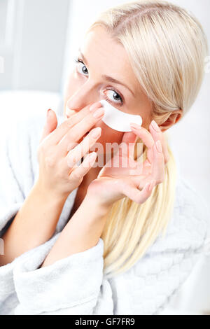 La femme d'apprêt appliquée sur le visage à l'aide d'une éponge spéciale maquillage. Banque D'Images