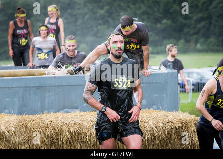 Des profils concurrents plongeant dans l'escalade et d'une piscine remplie de glace dans un événement Total Warrior à Leeds, 2016 Banque D'Images