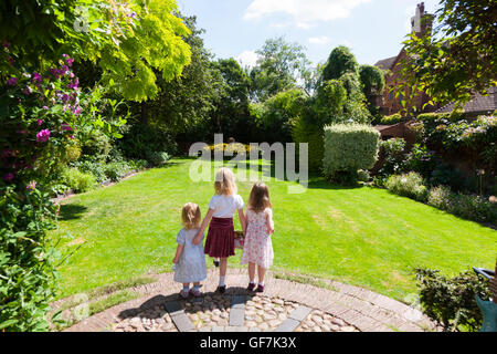 La maison et les jardins de Greyfriars avec 3 enfants / kids / kid à propos de courir et jouer sur la pelouse du jardin de l'herbe. Friar Street, Worcester. UK Banque D'Images