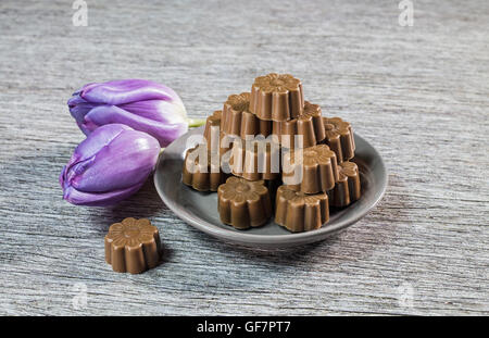 Quelques chocolats still life with purple tulips. Banque D'Images