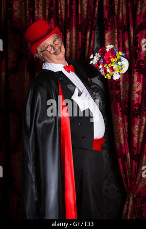 Fier magicien sur scène montrant un bouquet de fleurs Banque D'Images