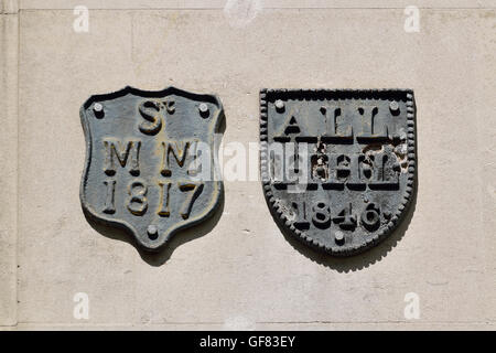 Londres, Angleterre, Royaume-Uni. Plaques d'assurance-incendie / fire marques sur un mur dans Cheapside, dans la ville... Banque D'Images