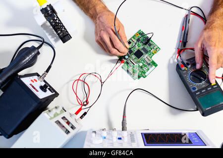 Développement de dispositifs électroniques dans le laboratoire d'électronique moderne, sur une table, microprocesseur oscilloscope et multimètre Banque D'Images