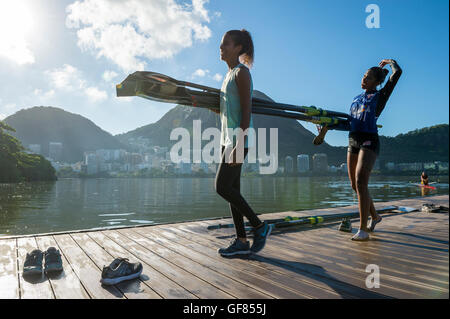 RIO DE JANEIRO - le 22 mars 2016 : Après la formation, deux rameurs brésilien porter leur bateau dans le clubhouse à Lagoa. Banque D'Images