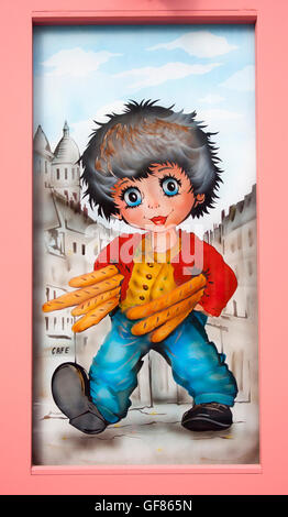 La charmante œuvre « Boy with baguettes » décore une boutique à Montmartre, Paris, ajoutant fantaisie aux rues artistiques du quartier. Banque D'Images