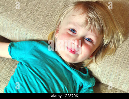 Portrait of a smiling boy lying on the bed Banque D'Images