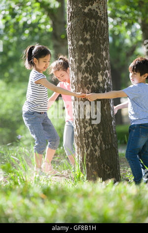 Heureux les enfants chinois jouant dans woods Banque D'Images