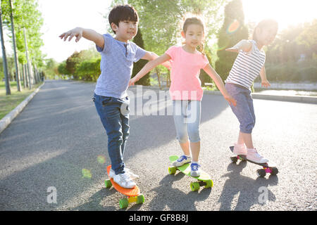 Heureux les enfants chinois skateboarding Banque D'Images