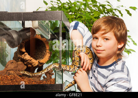 Young boy holding petit python royal Banque D'Images