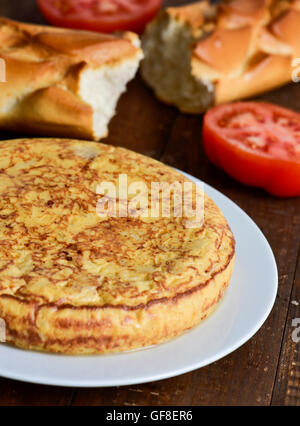 Libre d'une plaque avec une tortilla de patatas typique, une omelette espagnole, sur une table en bois foncé Banque D'Images