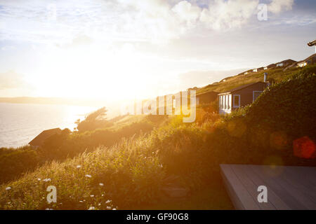 Coucher de soleil sur la maison de vacances chalets at Whitsand Bay qui surplombent, Cornwall, England, UK Banque D'Images