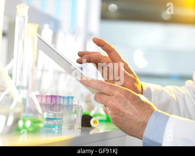 Parution de la propriété. Parution du modèle. Chercheur scientifique à l'aide d'une tablette numérique pour entrer des données dans un laboratoire pendant une expérience. Banque D'Images