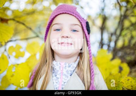Parution du modèle. Fille blonde wearing woolly hat and smiling, close-up, portrait. Banque D'Images