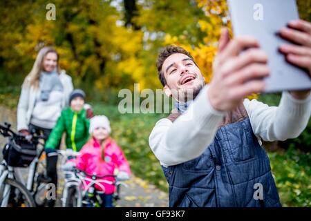 Parution du modèle. Smiling man taking photo de famille. Banque D'Images