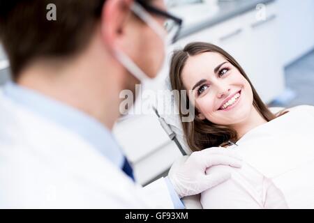 Parution du modèle. Dentiste et patient smiling in dentiste clinique. Banque D'Images