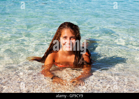 Jeune adolescent bronzé tourist baignade dans les eaux limpides de la mer Méditerranée à la plage d'Antisamos, l'île de Céphalonie, Grèce Banque D'Images