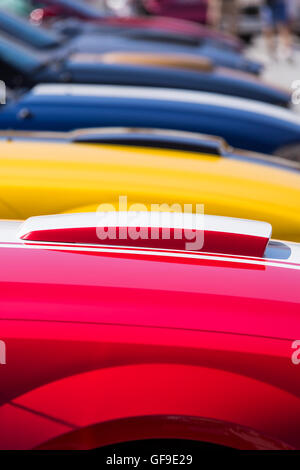 Rangée de Ford Mustang couleur bonnets en rouge, jaune, bleu, garée à côté de l'autre Banque D'Images