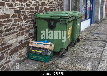 Un couple de recyclage industriel wheely poubelles et boîtes à déchets à l'extérieur d'un magasin à Truro, Cornwall. Les poubelles à l'extérieur de l'atelier. Les déchets commerciaux. Banque D'Images