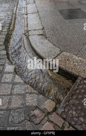 Street / drainage caniveau à Truro, Cornwall. Métaphore visuelle pour "l'argent en bas du drain' et le gaspillage de l'eau / le gaspillage de l'eau. Banque D'Images
