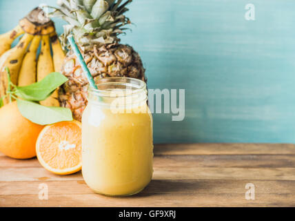 Jaune et orange fraîchement mélangé de fruits dans un bocal en verre avec de la paille Banque D'Images