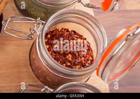 Flocons de piment rouge dans un bocal en verre. Banque D'Images