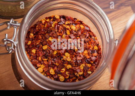 Les flocons de piment rouge dans un bocal en verre. Banque D'Images