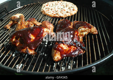 Griller le poulet et la pizza sur le grill en plein air Banque D'Images