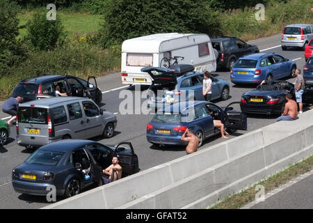 Edingworth, Weston-Super-Mare, Somerset, Royaume-Uni. 30 juillet, 2016. Les longues files de l'arrêt de la circulation sur l'autoroute M5 dans le Somerset près de Weston super Mare. De nombreux groupes de sortir de leurs voitures dans la chaleur. 30 juillet 2016. Credit : TimothyLarge/Alamy Live News Banque D'Images