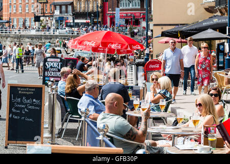 Front de l'Anglais à Ramsgate avec des gens assis à des tables et des chaises à l'ombre des parasols, prendre un verre au cours de temps très chaud en été. Banque D'Images