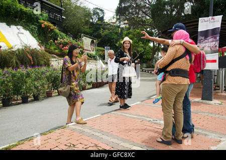 Les femmes thaïlandaises voyageur aider prendre une photo pour les voyageurs à la famille malaisienne de Penang Hill viewpoint Penang Hill le 26 avril 2016 Banque D'Images
