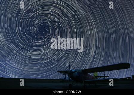 Beau ciel nocturne, Spiral Star Trails plus petit aéroport avion solitaire. Star Trails Vortex. Banque D'Images