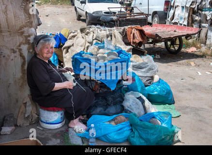 Femme vendant des bas de laine et autres étoffes de laine produits au marché dans le quartier de bazar. Korca, sud-est de l'Albanie. Banque D'Images