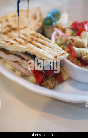 Panini poulet aux champignons grillés avec une salade de pâtes et de chou pickle Banque D'Images