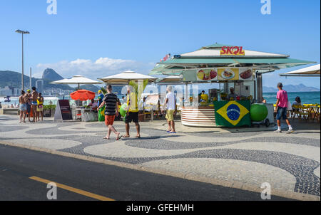 Les piétons vous détendre sur la plage de Copacabana. Rio de Janeiro accueillera les Jeux Olympiques d'été en août 2016. Banque D'Images