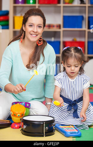 Petite fille jouant des instruments de musique avec sa maman Banque D'Images