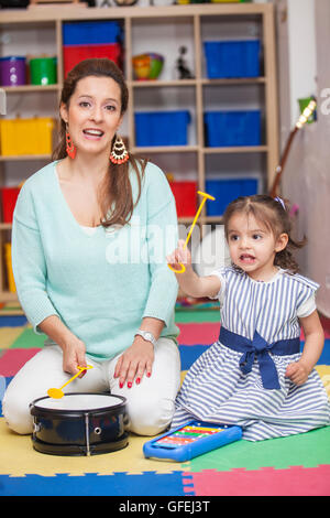 Petite fille jouant des instruments de musique avec sa maman Banque D'Images