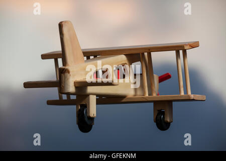 Avion en bois volant sous le ciel d'orage - s'en aller Banque D'Images