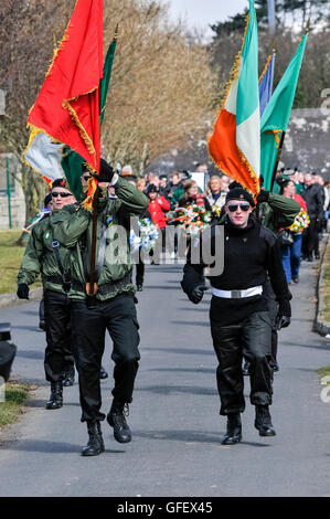 Irish Republican Socialist Party (IRSP) membres en uniformes paramilitaires porter drapeaux républicaine irlandaise au cours d'une insurrection de Pâques commémoration en souvenir de l'Armée de libération nationale irlandaise (AIDN) bénévoles, Belfast, en Irlande du Nord Banque D'Images