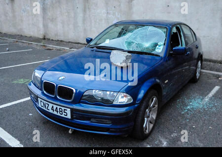 Belfast, Irlande du Nord. 9 Août 2013 - une voiture de BMW bleu a ses fenêtres brisées à la suite des troubles de manifestants loyalistes à la suite d'un internement en parade anti-républicains à Belfast Banque D'Images