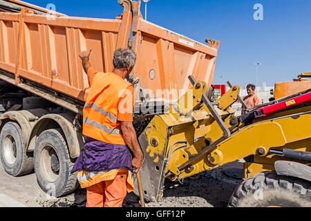 Zrenjanin, en Voïvodine, Serbie - Septembre 14, 2015 : camion Dumper est le déchargement l'asphalte dans la gamme excavator at construction site. Banque D'Images