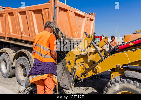 Zrenjanin, en Voïvodine, Serbie - Septembre 14, 2015 : camion Dumper est le déchargement l'asphalte dans la gamme excavator at construction site. Banque D'Images