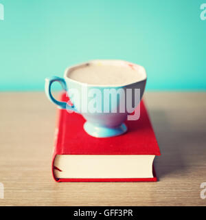 Tasse à café bleu sur le livre rouge vintage Banque D'Images