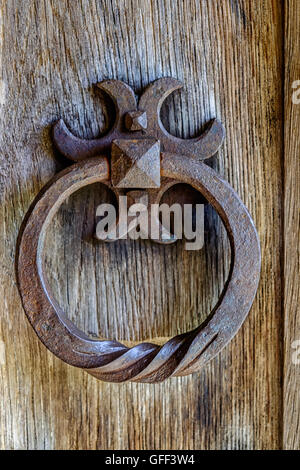 Ancienne ouvragée fer rouillé heurtoir de porte en bois de section Banque D'Images