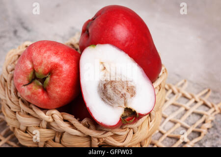 Fruits tropicaux Acmella oleracea (mal de dents, de l'usine, paracress electric daisy, le jambu) dans panier en osier sur la table de marbre. Selective Banque D'Images