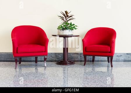 Table et fauteuils rouge moderne dans un hall d'accueil Banque D'Images