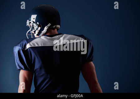 Joueur de football américain, en uniforme, sur un fond bleu. Banque D'Images