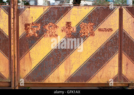 Rusty japonais bande noire et jaune métal à motifs mur à la vue de la construction Banque D'Images