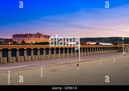 Deauville au crépuscule avec une promenade des Plances vide et illuminé big Casino Barrière dans l'arrière-plan Banque D'Images