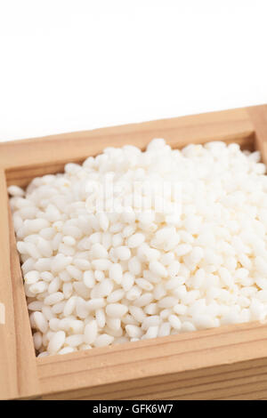Le riz collant dans le saké japonais appelé tasse blanc fond isolé sur Masu Banque D'Images