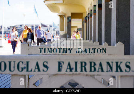 Des noms célèbres, peint en face de cabanes de plage sur la promenade du bord de mer de Deauville, France. Banque D'Images